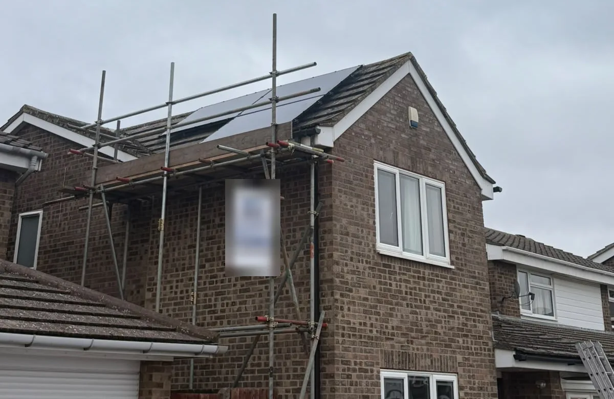 Scaffolding up and all-black DMEGC solar panels going onto a Bedford roof on install day