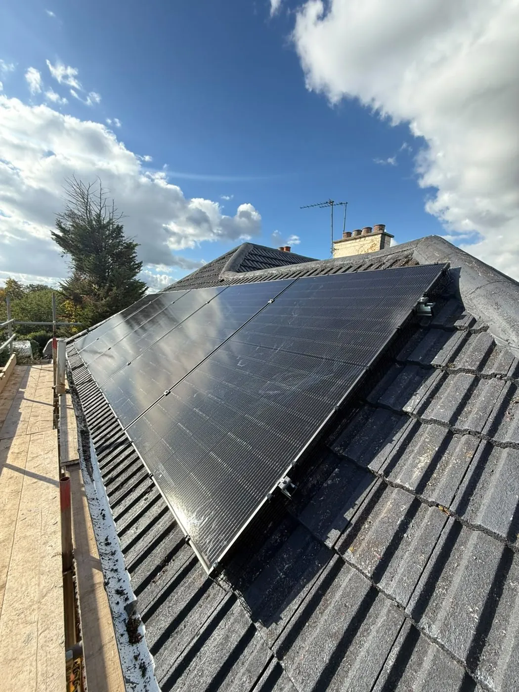 All-black DMEGC panels under a blue sky on the Romford roof