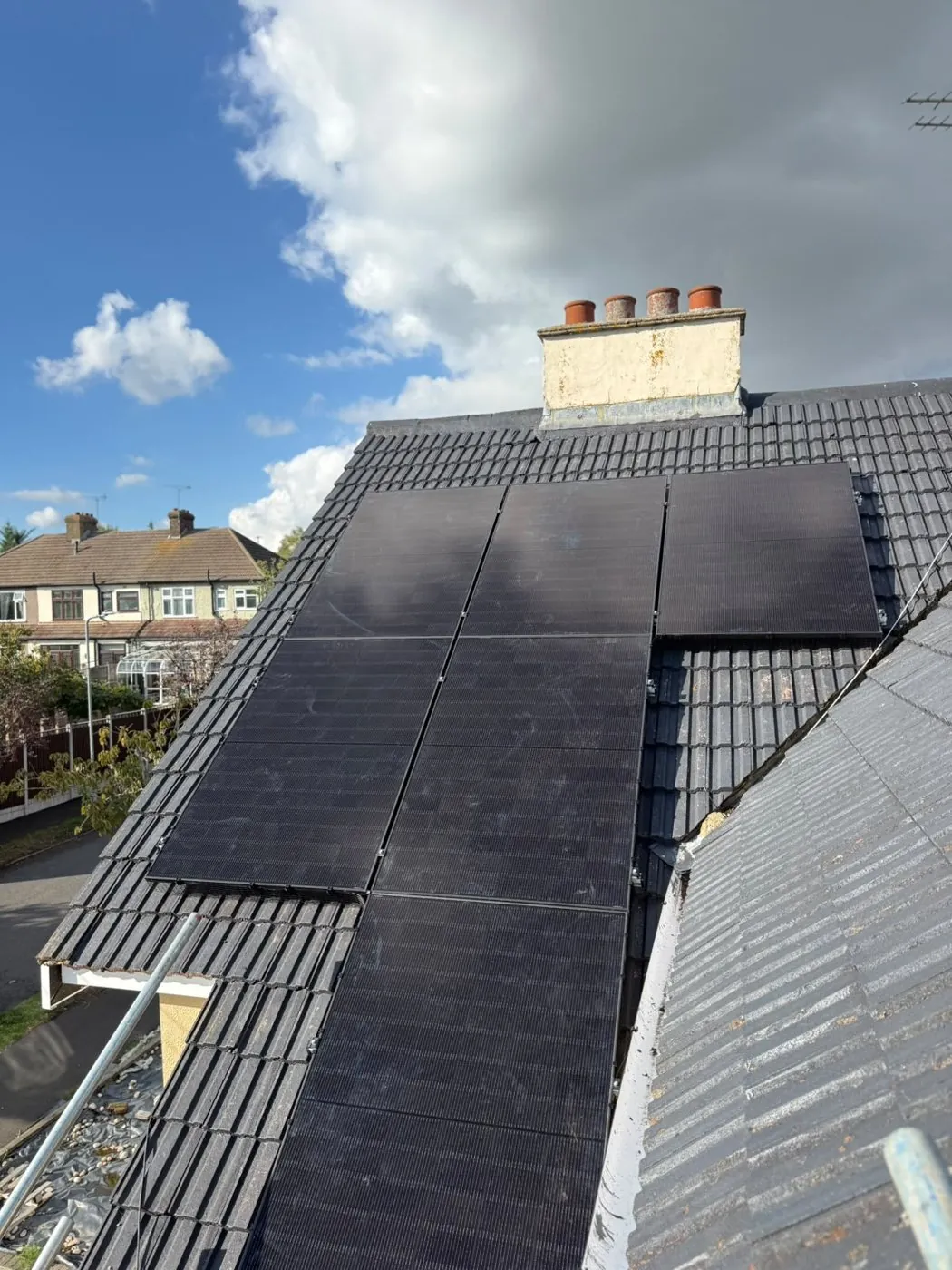 Twelve all-black DMEGC panels across two faces of the Romford hip roof
